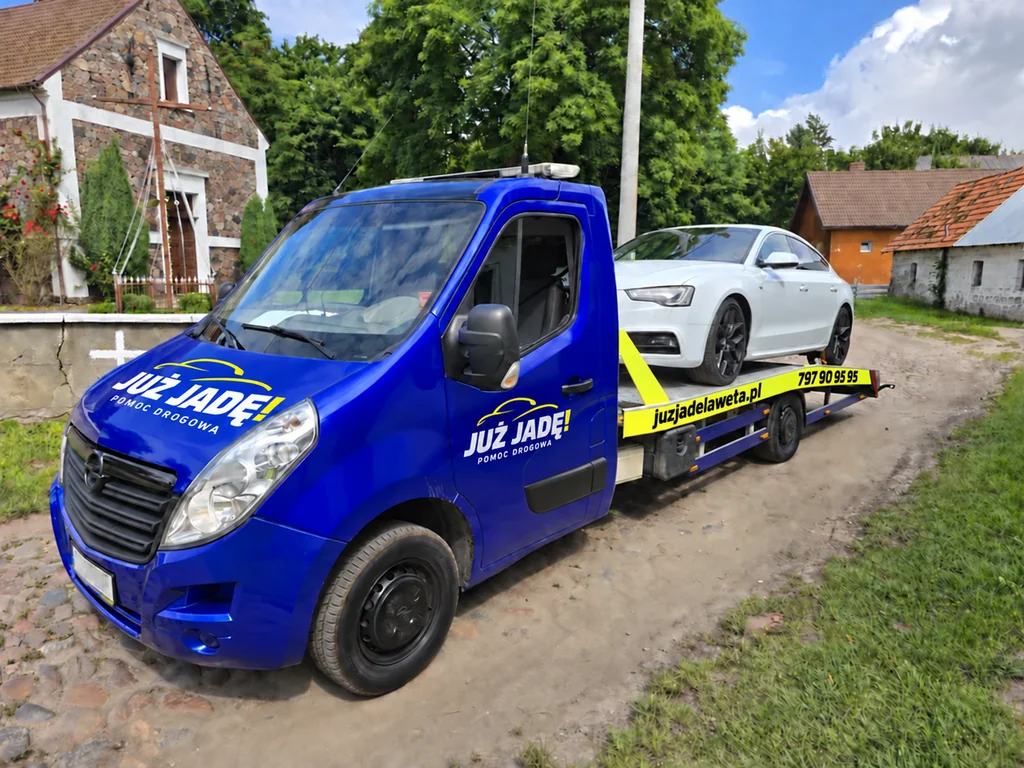 Białe Audi na autolawecie z wizualizacją oznakowania Już Jadę!